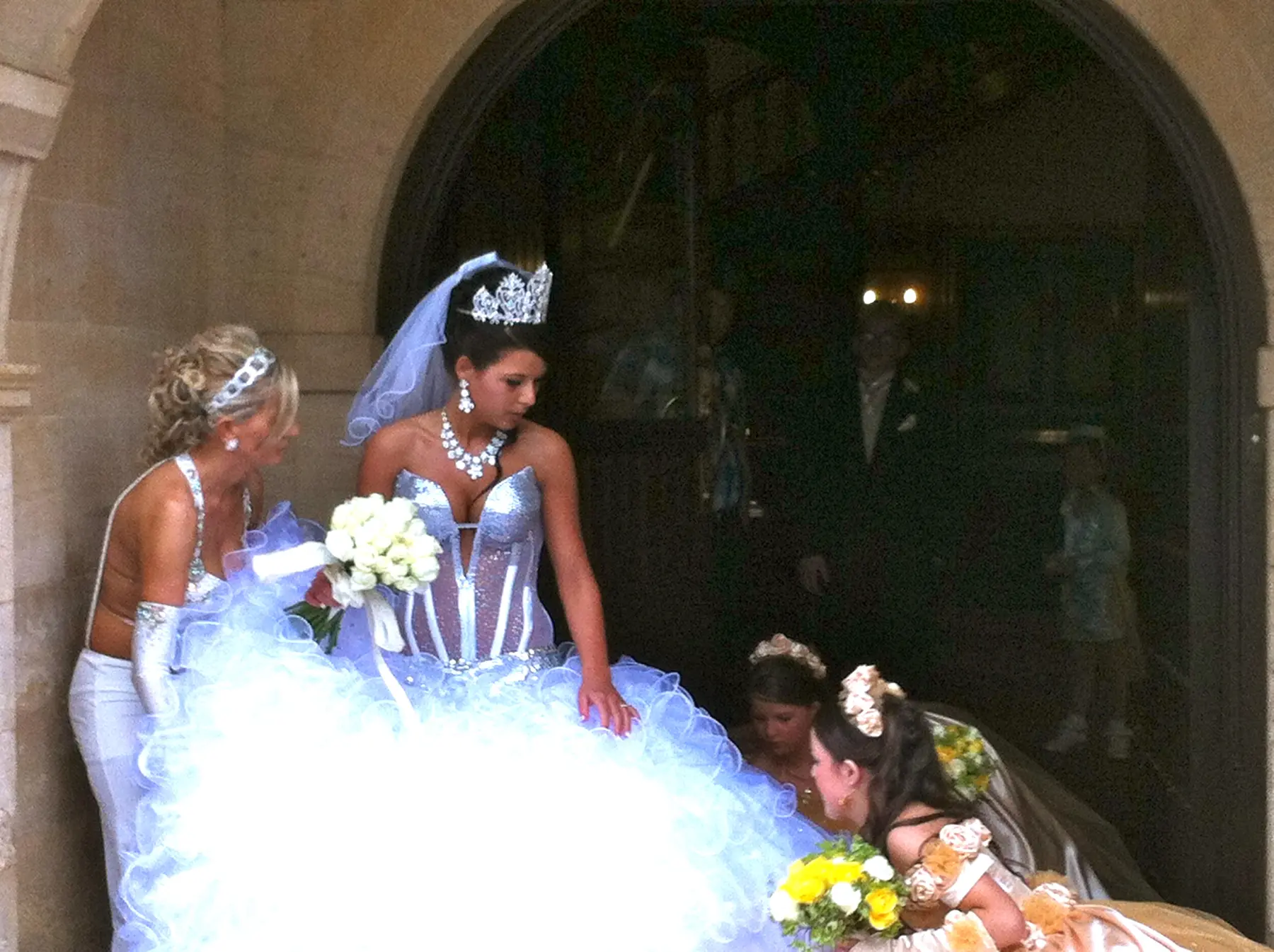 Close-up of gypsy wedding bride wearing crystal corset bodice and crown tiara at church doorway