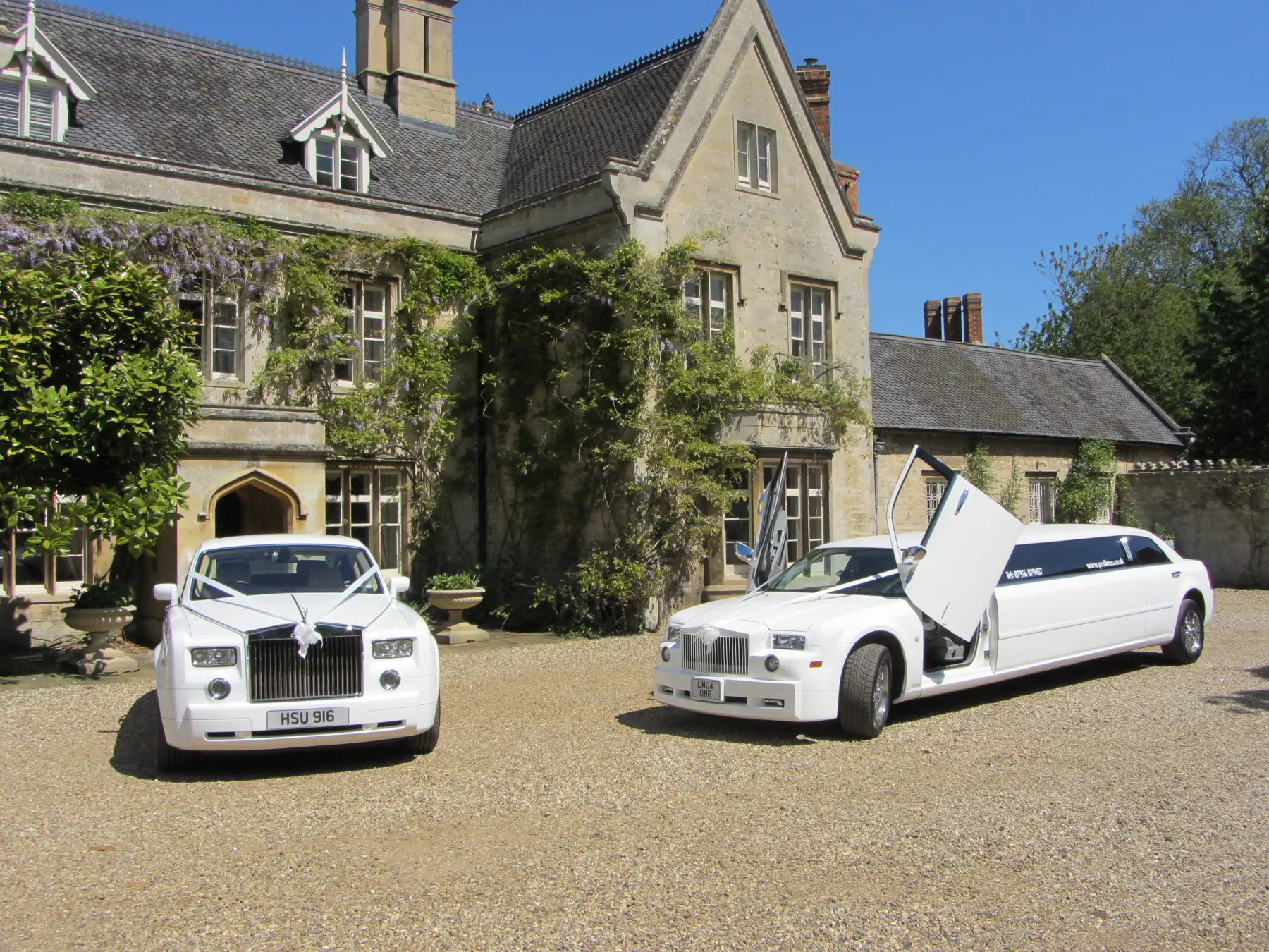 White Rolls-Royce Phantom and stretch limousine with scissor doors open outside grand manor house