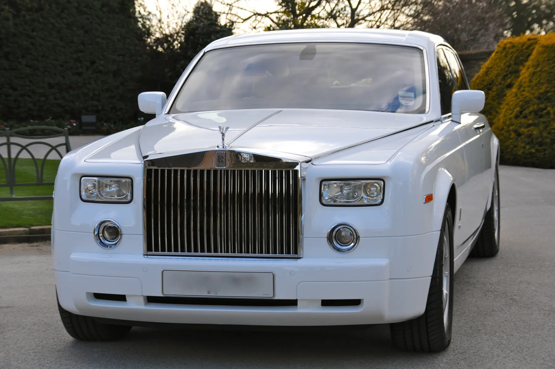Front close-up of white Rolls-Royce Phantom showing chrome grille and Spirit of Ecstasy