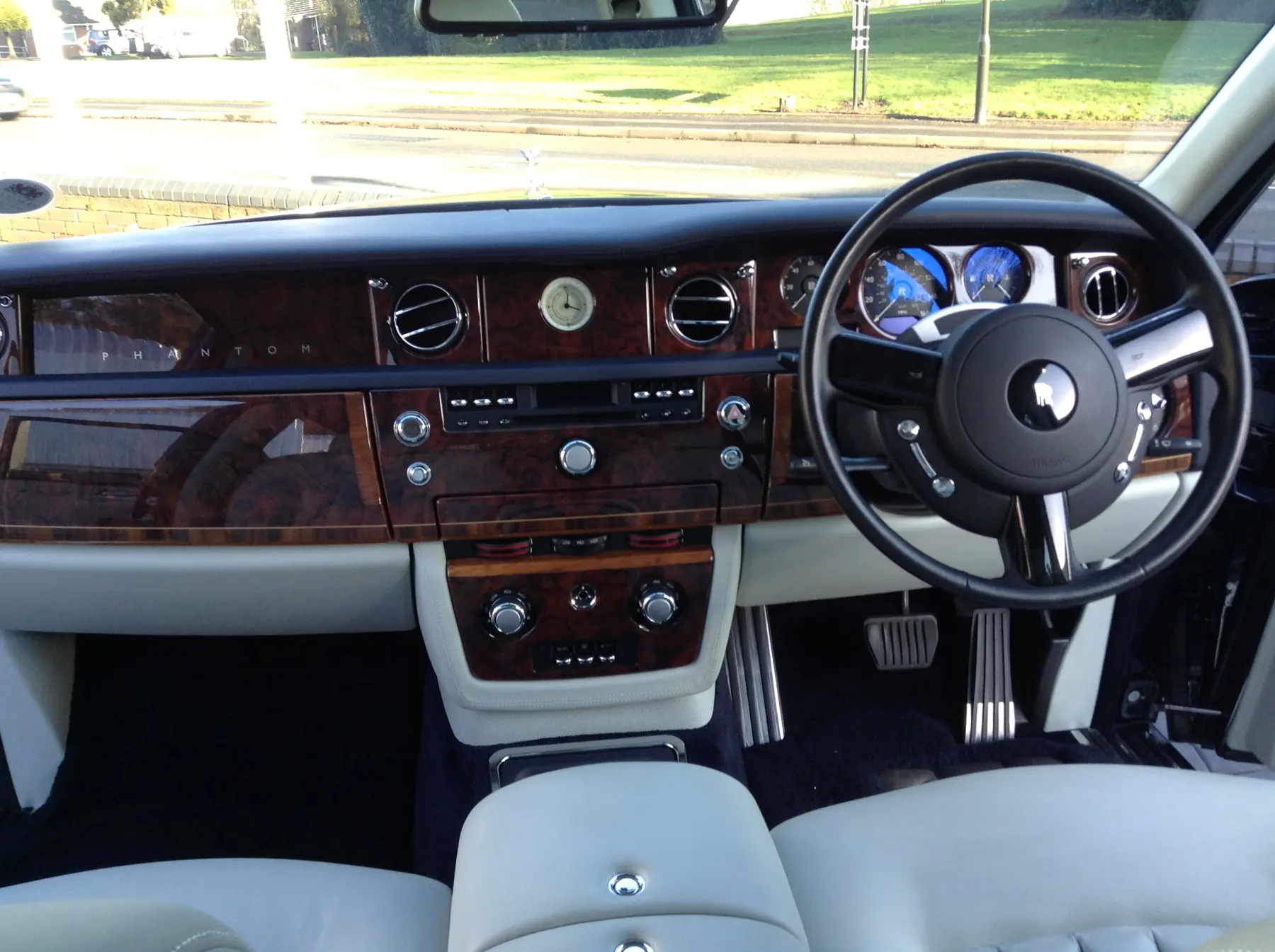 Luxury walnut burr dashboard, steering wheel and instrument cluster of Rolls-Royce Phantom